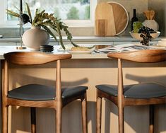 two wooden chairs sitting on top of a counter