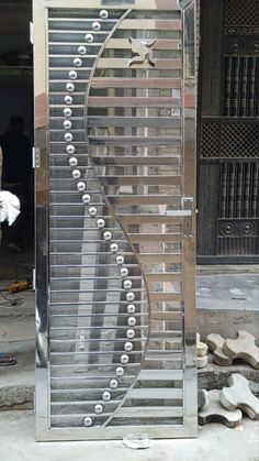 a large metal object sitting on top of a cement floor next to a building with doors