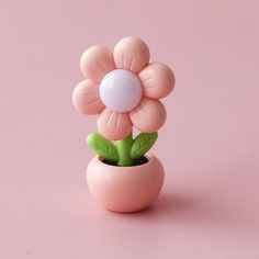 a pink vase with a flower in it