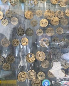 there are many gold coins on display in the shop window, all with arabic writing