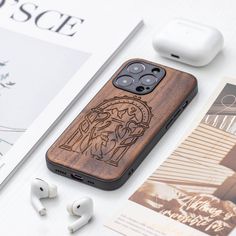 an iphone case is sitting next to earbuds and headphones on a table