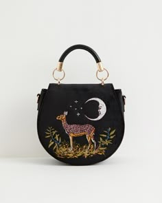 Embark on a moonlit adventure with our Deer & Moon Embroidered Saddle Bag. Crafted from sumptuous black velvet, this bag features a rounded, saddle-shaped silhouette adorned with detailed embroidery depicting a fawn gracefully positioned beneath a celestial crescent moon—an embodiment of the feminine, symbolising t Fable England, Luxury Christmas Gifts, Twilly Scarf, Retro Bags, Talisman Necklace, Christmas Style, Animal Brooch, Embroidered Bag, Saddle Bag