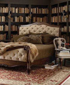 a large bed sitting in front of a book shelf filled with books