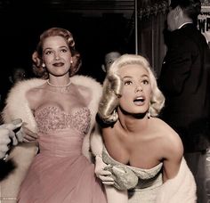 black and white photograph of two women dressed in evening gowns, one with her mouth open