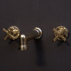 two metal knobs on the side of a black wall