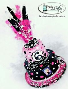 a pink and black birthday hat with feathers