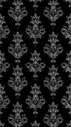 black and white damask wallpaper with silver swirls on the bottom right corner