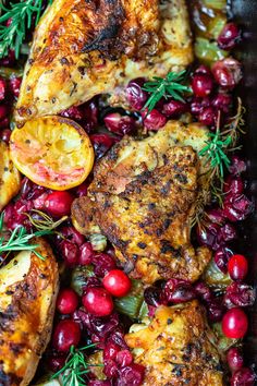 roasted chicken with cranberries and rosemary garnish in a roasting pan