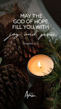 a candle and pine cones with the words, may the god of hope fill you with joy and peace