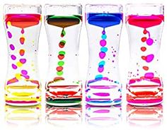 four different colored vases with liquid pouring out of them