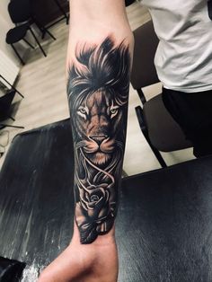 a man's arm with a lion and roses tattoo on the left side of his leg