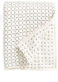 a white quilted blanket on top of a bed