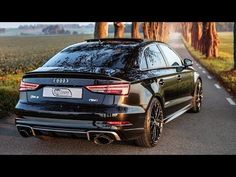 an audi car parked on the side of a road next to some trees and grass