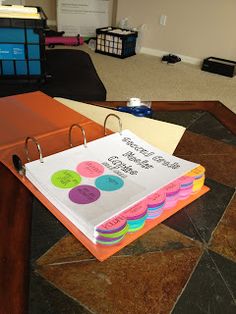 a binder that is sitting on top of a table in an office with several folders