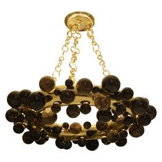 a gold chandelier with brown beads hanging from it's center chain, against a white background