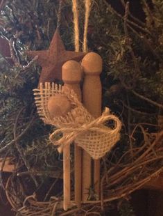 an ornament hanging from a christmas tree with two wooden figures on it's side