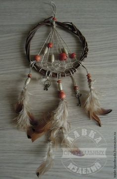 a dream catcher with feathers and beads hanging from it