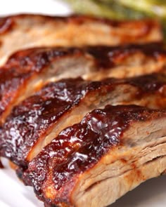 ribs covered in bbq sauce on a white plate