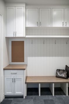 a white bench and cabinets in a room