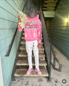 a person standing on some stairs with a fan in their hand and money in her other hand