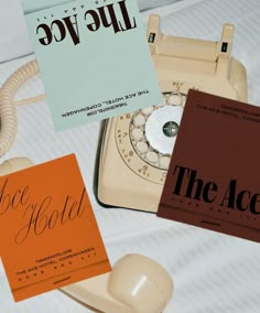 an old fashioned telephone and two business cards on a bed