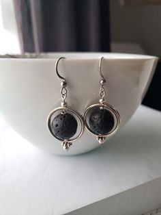 Silver circle earrings with black lava stones on stainless steel hooks.  Essential oil can be put on the stones for aromatherapy. Approx. 1.5 in. long See also the matching necklace in my store...and the antique brass version available also Lava Jewelry, Peridot Birthstone, Silver Circle Earrings, Silver Circle, Triangle Earrings, Lava Stone, Hammered Silver, Matching Necklaces, Circle Earrings