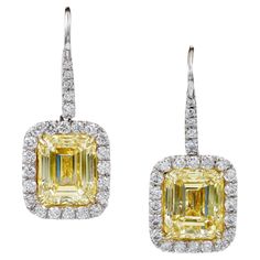 Channel Young Hollywood glamour with these Contemporary Emerald Cut Yellow Diamond Halo Drop Earrings, reminiscent of styles worn by Kelly Clarkson, Jennifer Lopez, and Carrie Underwood. Crafted in platinum, this 21st-century pair features two GIA-certified, rectangular emerald-cut yellow diamonds with a total weight of 10.18 carats. These Fancy Intense Yellow diamonds boast VS2 clarity, offering a vibrant, elegant look perfect for any Red Carpet moment. The emerald cut enhances the rich color, making these earrings both timeless and on-trend. Measures approx. 1.25" x 0.5", designed for pierced ears. 2 emerald cut yellow diamonds weighing approx. 10.18 carats total, VS2 clarity; EGL USA and GIA certified natural color. 50 round white diamonds weighing approx. 1.38 carats total. Overall wei Emerald Earrings Drop, Yellow Diamonds, Fancy Lights, Fancy Yellow Diamond, Colombian Emeralds, Radiant Diamond, Kelly Clarkson, Diamond Drops, Carrie Underwood