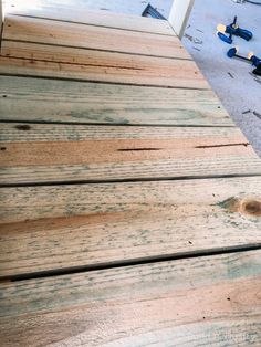 some tools are laying on the ground next to wooden planks that have been stripped off