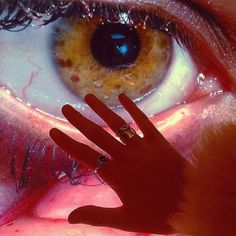 a woman's face with her hand in front of her eye and the image of a cat