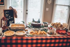 a table topped with lots of food next to windows