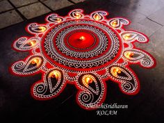 an intricately decorated diya with candles on the ground