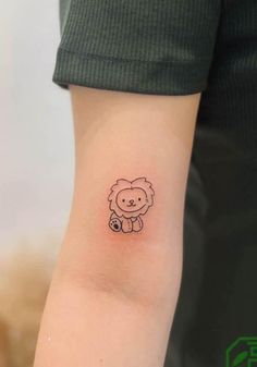 a small tattoo on the arm of a person with a lion design on it's left arm