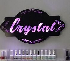 a sign that says crystal on the side of a wall with nail polish bottles in front of it