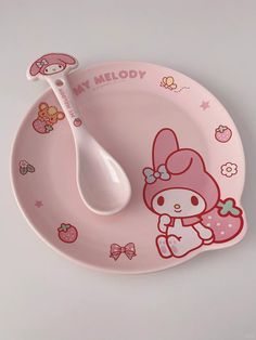 a pink hello kitty plate with a spoon