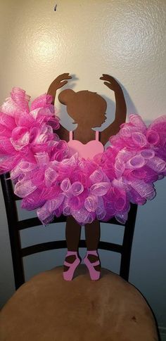 a paper cut out of a girl on top of a chair with pink tulle