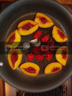 the fruit is being cooked in the pan on the stove top with garlic and peppers