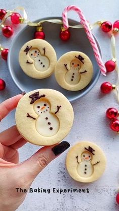 someone is holding some cookies decorated like snowmen