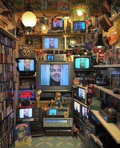 a room filled with lots of different types of tvs and books on shelves next to each other