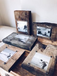 three wooden frames sitting on top of a table next to each other with pictures in them