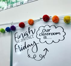 a white board with writing on it and pom - poms around the edges