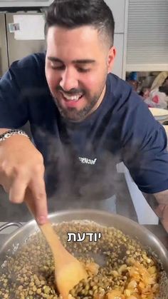 a man stirring food in a pan with a wooden spoon