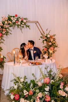 a bride and groom kissing at their table