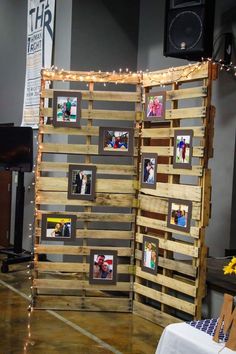 a display made out of pallets with pictures and lights on the wall behind it