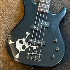 a black bass guitar with a skull and crossbones on it's body