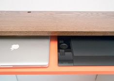 an orange shelf with two laptops on it