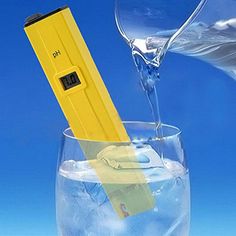 a yellow thermometer sticking out of a glass filled with water