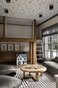 a living room filled with furniture and a wooden table in front of a large window