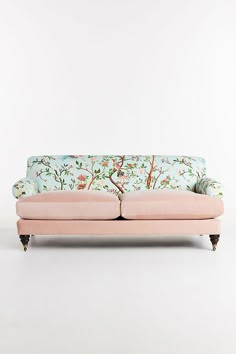 a pink couch sitting on top of a white floor