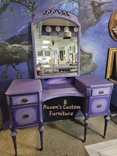 a purple vanity with an ornate mirror on it