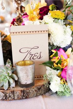 a table with flowers, candles and a sign that says tress on the side